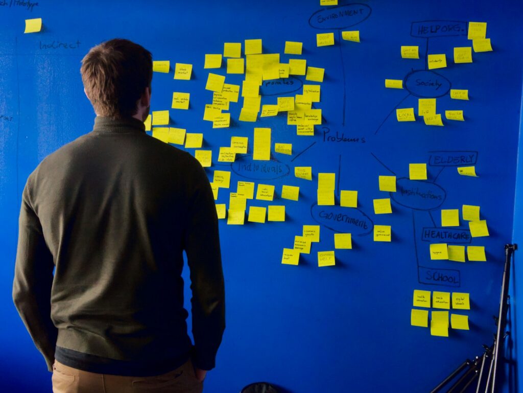 man in gray long sleeve shirt standing in front of blue and yellow puzzle mat